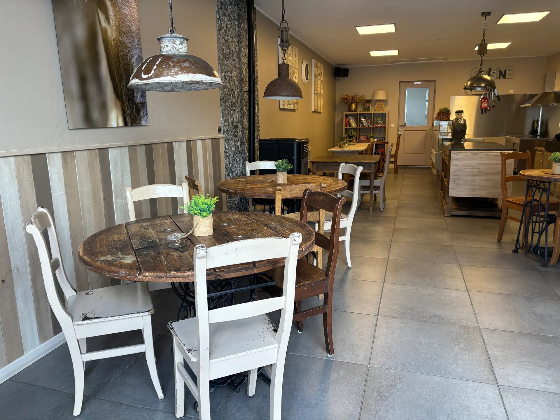 Tables rondes en bois et vue vers la cuisine ouverte